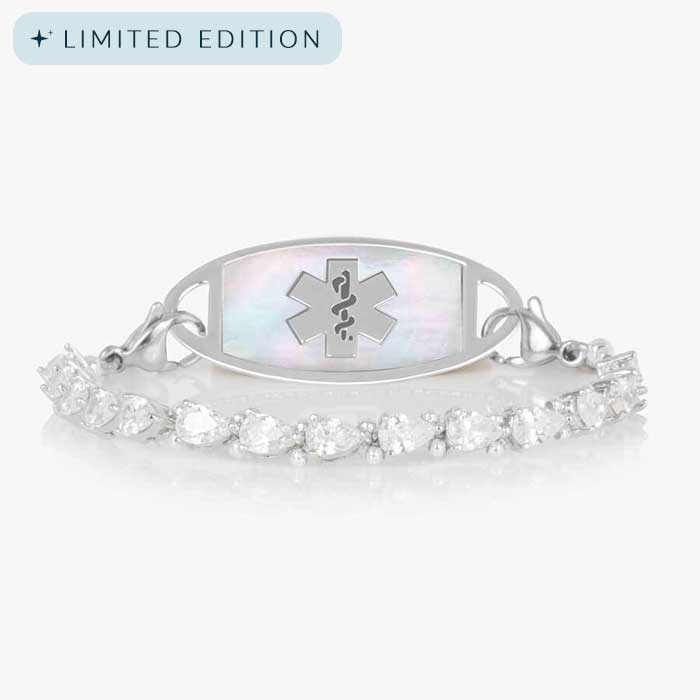 Rhodium-plated stretch medical alert bracelet with pear-cut CZ stones and white mother-of-pearl tag engraved with medical symbol, shown on clean white background.