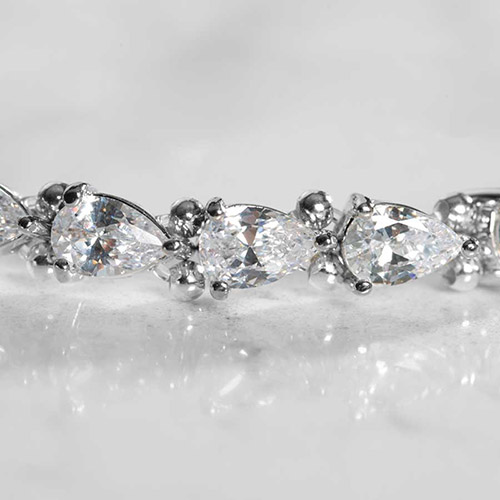 Close-up of rhodium-plated women's stretch bracelet with pear-shaped cubic zirconia links, highlighting the sparkle and secure prong settings.