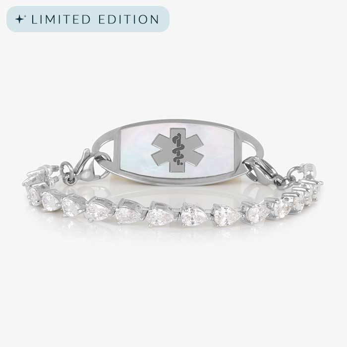 Rhodium-plated stretch medical alert bracelet with pear-cut CZ stones and white mother-of-pearl tag engraved with medical symbol, shown on clean white background.