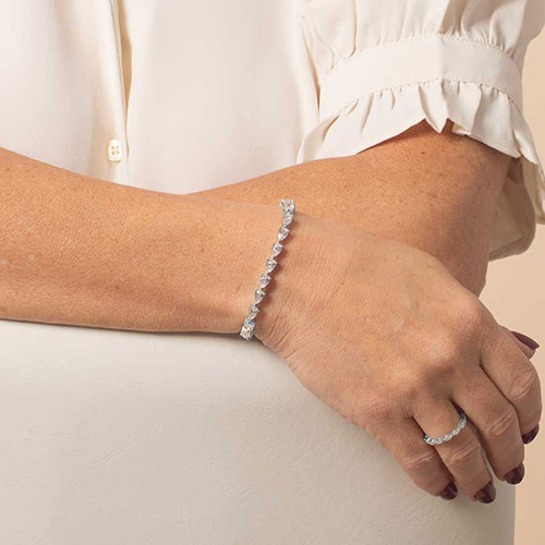 Elegant silver Jackie bracelet featuring pear-cut CZ stones in a tennis-style design, worn on wrist for a sophisticated look.