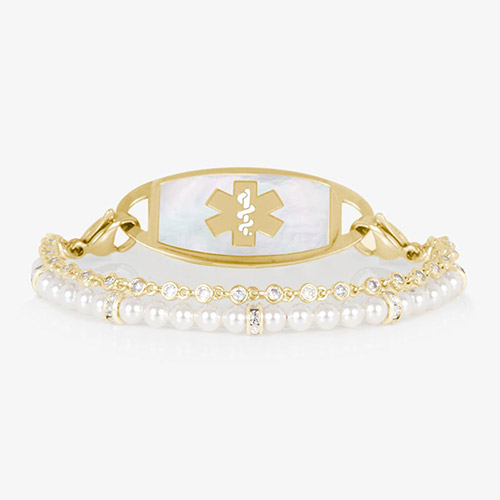 Charlotte Pearl medical ID bracelet in gold finish with a mother-of-pearl tag and gold medical symbol. Features two strands: one of white pearls and one of bezel-set CZ crystals.