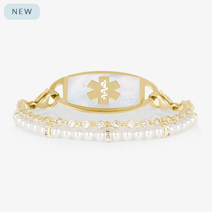 Charlotte Pearl medical ID bracelet in gold finish with a mother-of-pearl tag and gold medical symbol. Features two strands: one of white pearls and one of bezel-set CZ crystals.