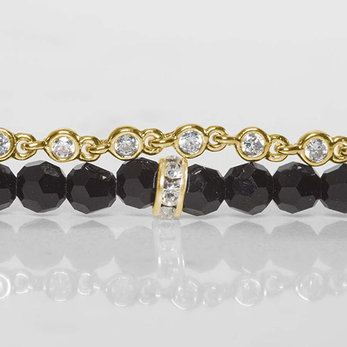 Close-up of the Charlotte bracelet's black faceted beads, crystal rondelles, and gold CZ chain, highlighting the fine details and craftsmanship.