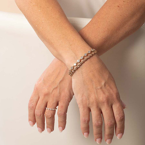 Rose gold Arden Medical ID bracelet styled on a woman's wrist, highlighting both strands in a stacked look.