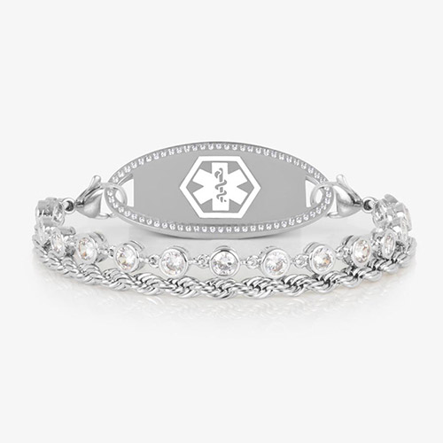 Silver medical ID bracelet featuring a dual-strand design with bezel-set clear crystals and a twisted rope chain, attached to an engravable silver ID tag with a white medical caduceus symbol.