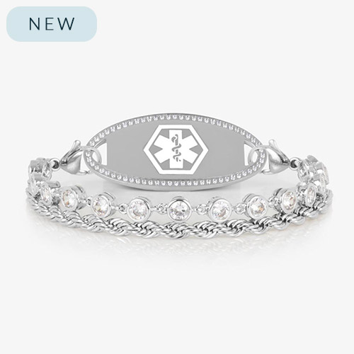 Silver medical ID bracelet featuring a dual-strand design with bezel-set clear crystals and a twisted rope chain, attached to an engravable silver ID tag with a white medical caduceus symbol.
