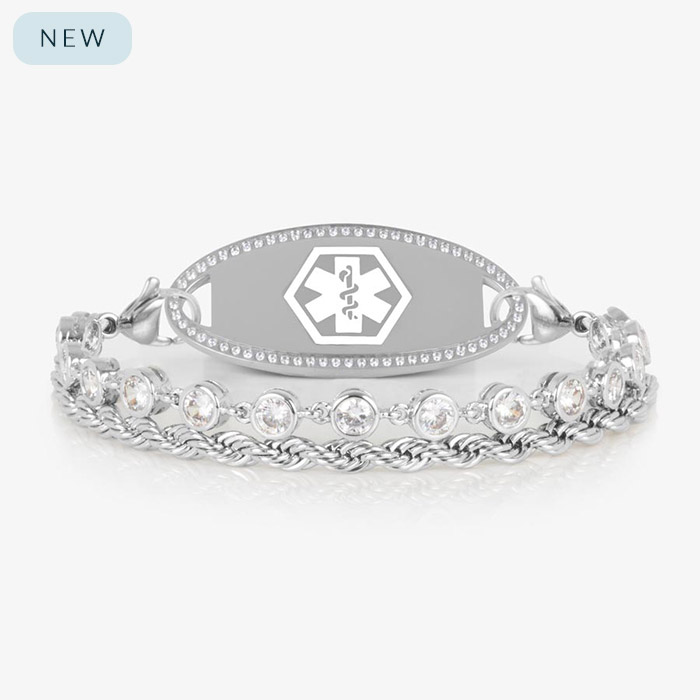 Silver medical ID bracelet featuring a dual-strand design with bezel-set clear crystals and a twisted rope chain, attached to an engravable silver ID tag with a white medical caduceus symbol.