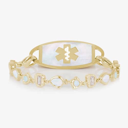 Gold-tone medical ID bracelet with a mother-of-pearl ID tag and alternating opalescent and light pink stones in geometric gold settings.