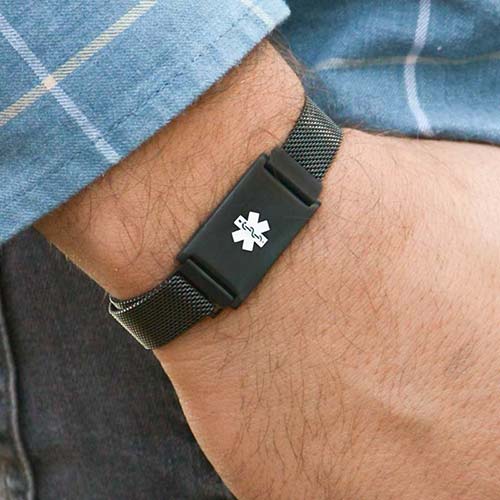Man wearing black mesh magnetic medical ID bracelet with white caduceus.