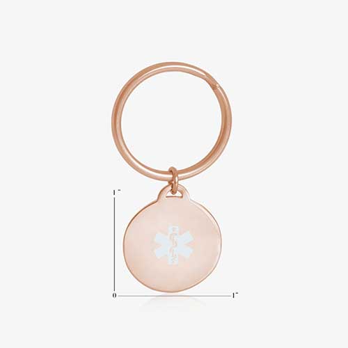 Key ID - rose gold tone circular charm with white medical caduceus symbol and rose gold keychain ring, showing charm measurements of one inch by one inch.